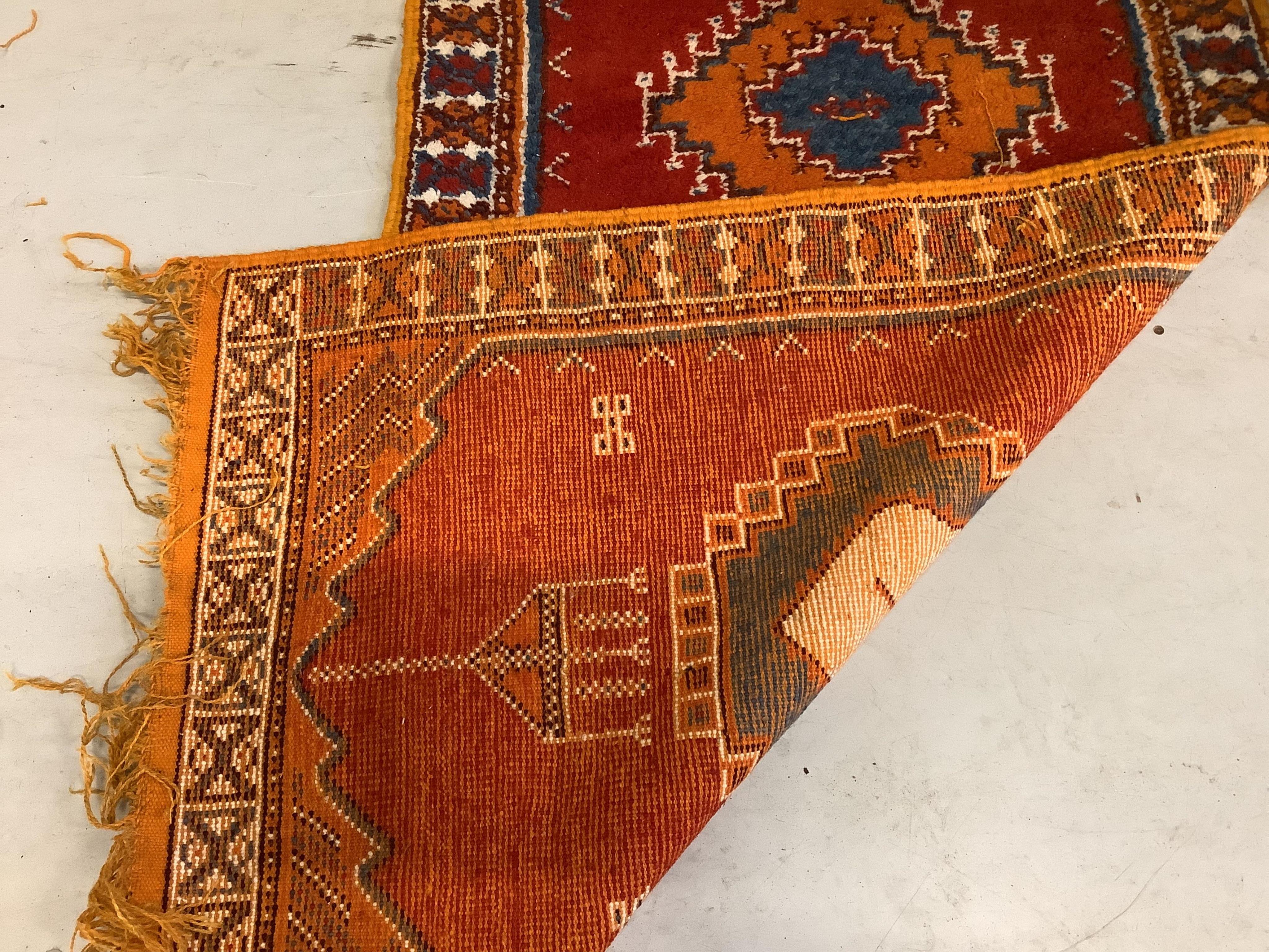 A Turkish red ground runner, woven with a row of hexagonal medallions, 375 x 89cm. Condition - fair